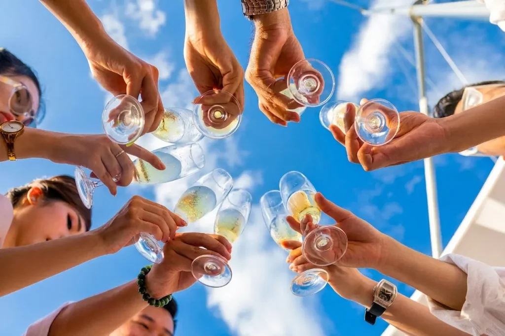 Local SEO for Wine Shops: A low-angle shot of a group of people clinking sparkling wine glasses against a bright blue sky, symbolizing local community, partnership, and successful events.